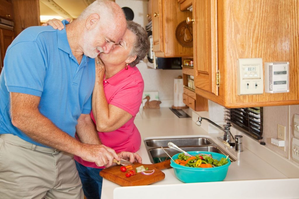 4783925 - senior man helping his wife in the kitchen of their rv gets rewarded with a kiss.