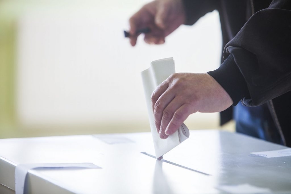 35240066 - hand of a person casting a ballot at a polling station during voting.