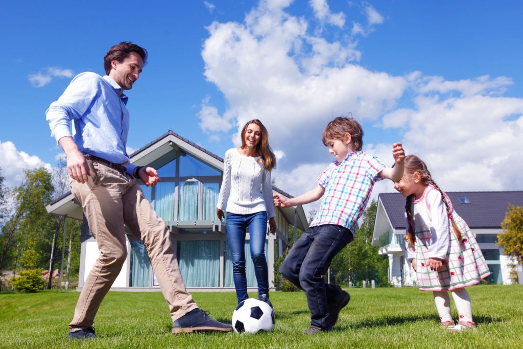 41190853 - family playing football in front of their house