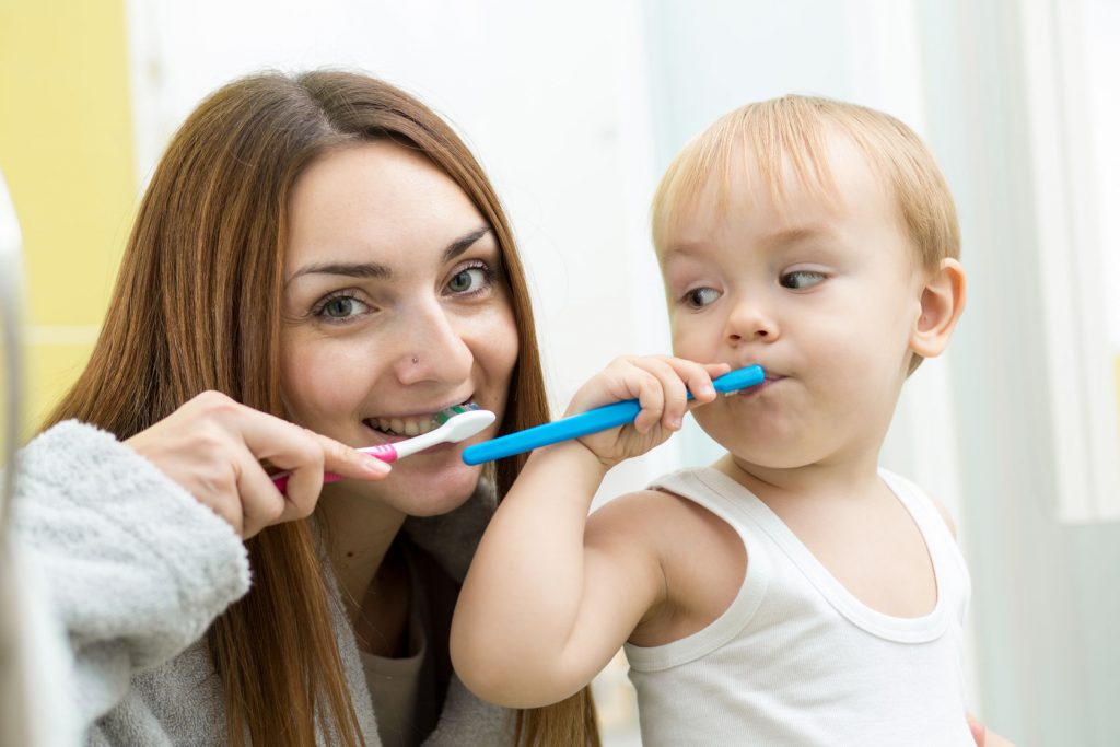 34023140 - mother and her kid son brushing teeth in bathroom